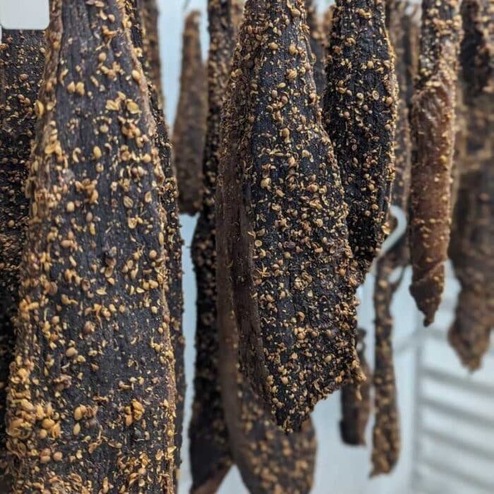 A group of biltong slabs hanging from a rack