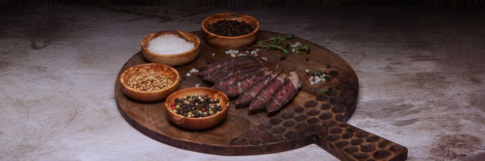 a cutting board with different bowls of spices and sliced biltong. What is biltong?
