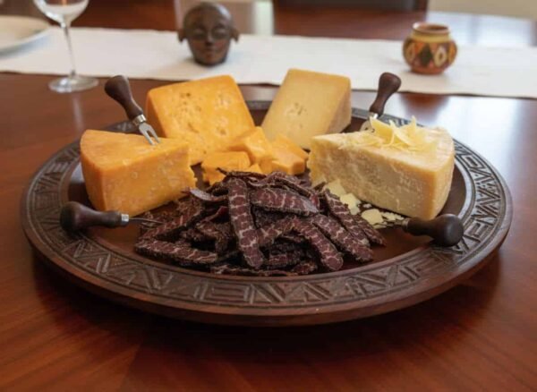 Pairing Biltong with assorted hard cheeses on a platter.